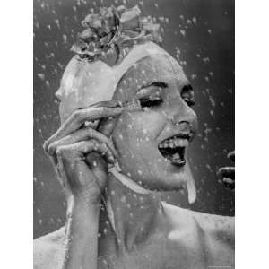 Woman Wearing Flowered Bathing Cap and Applying Mascara as 