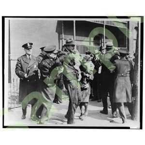  1933 Police subdue man carrying child as others look on 